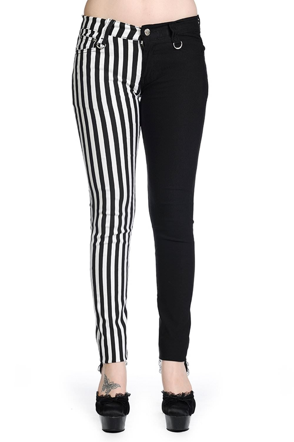 Low rise skinny jeans with one black leg and one black and white striped leg