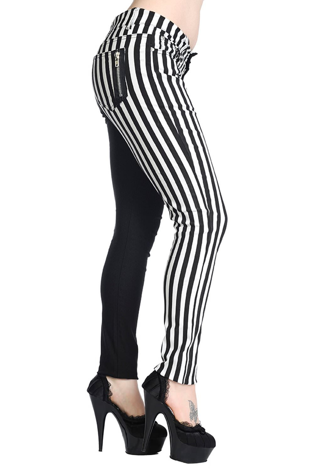 Low rise skinny jeans with one black leg and one black and white striped leg