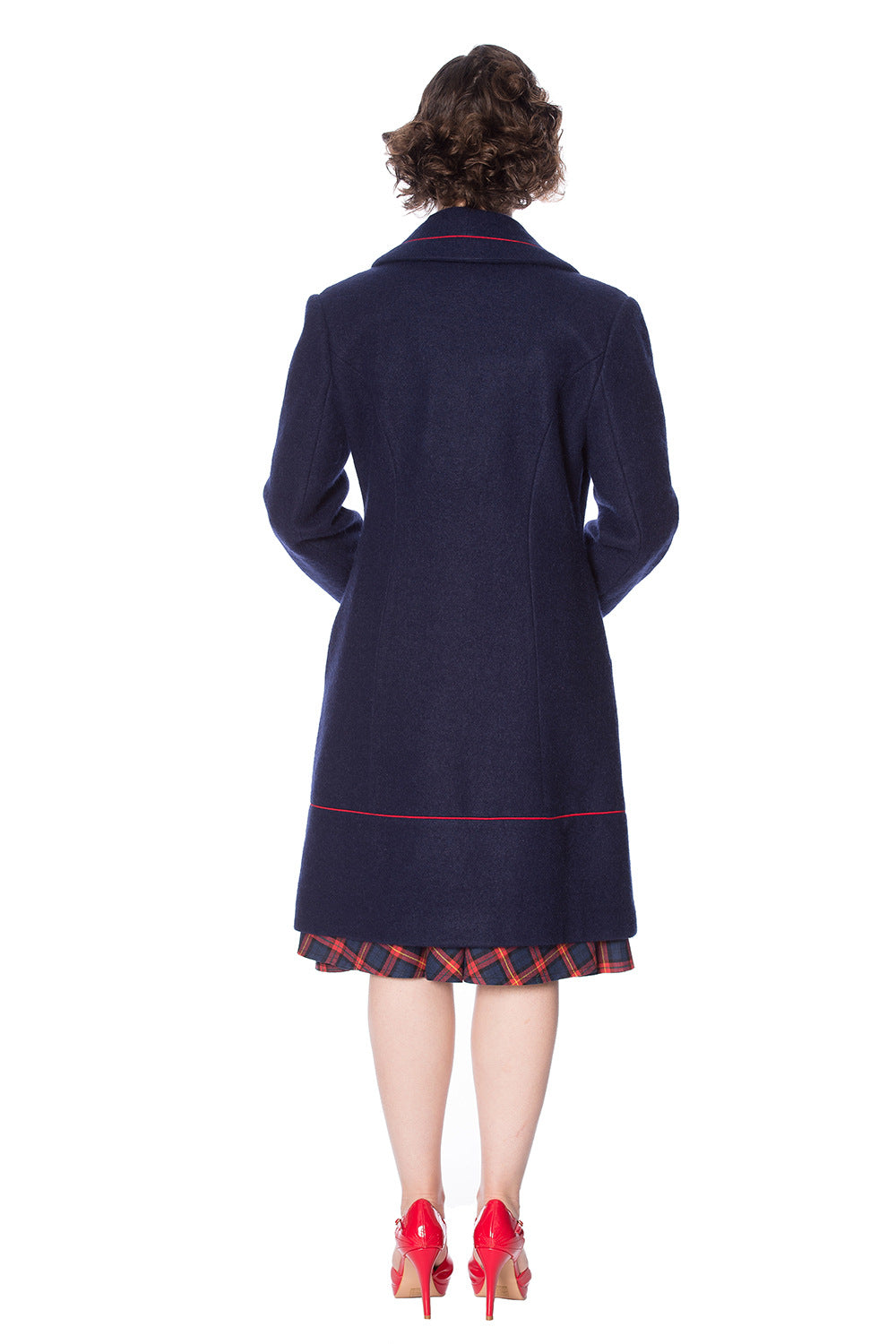 Retro model in navy long line coat with orange piping and buttons