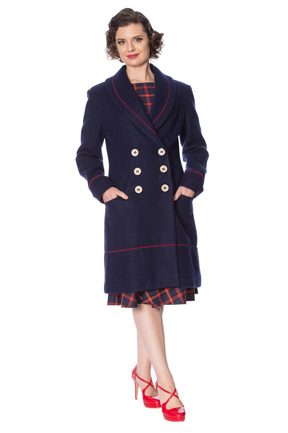 Retro model in navy long line coat with orange piping and buttons