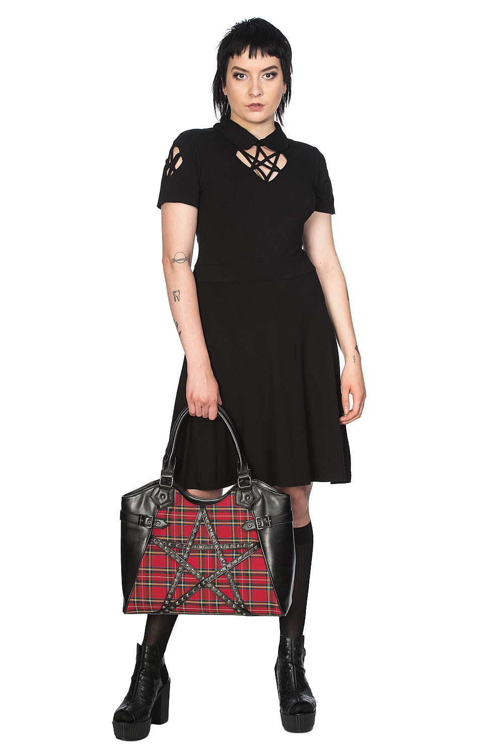 Alternative model in black dress holding red tartan hand bag with studded pentagram