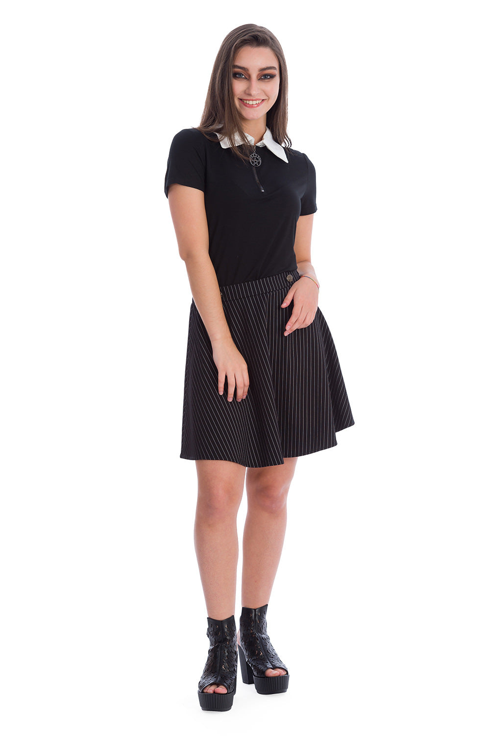 Model in black short sleeve top with white collar and pentagram pendant with pinstripe a line skirt