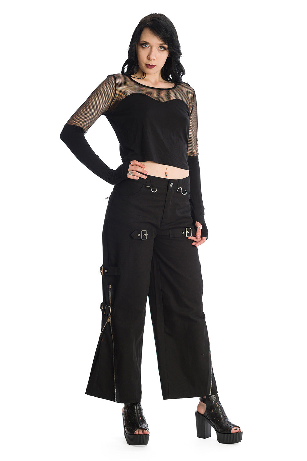 Grunge model wearing mesh long sleeve top with thumb holes in black with oversized black trousers with buckles