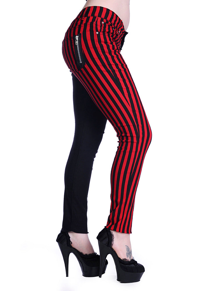 Low rise skinny jeans with one black leg and one black and red striped leg