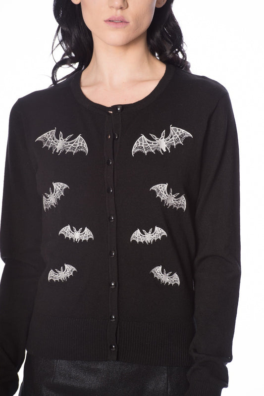 Close up shot of black cardigan with white lace bat motifs