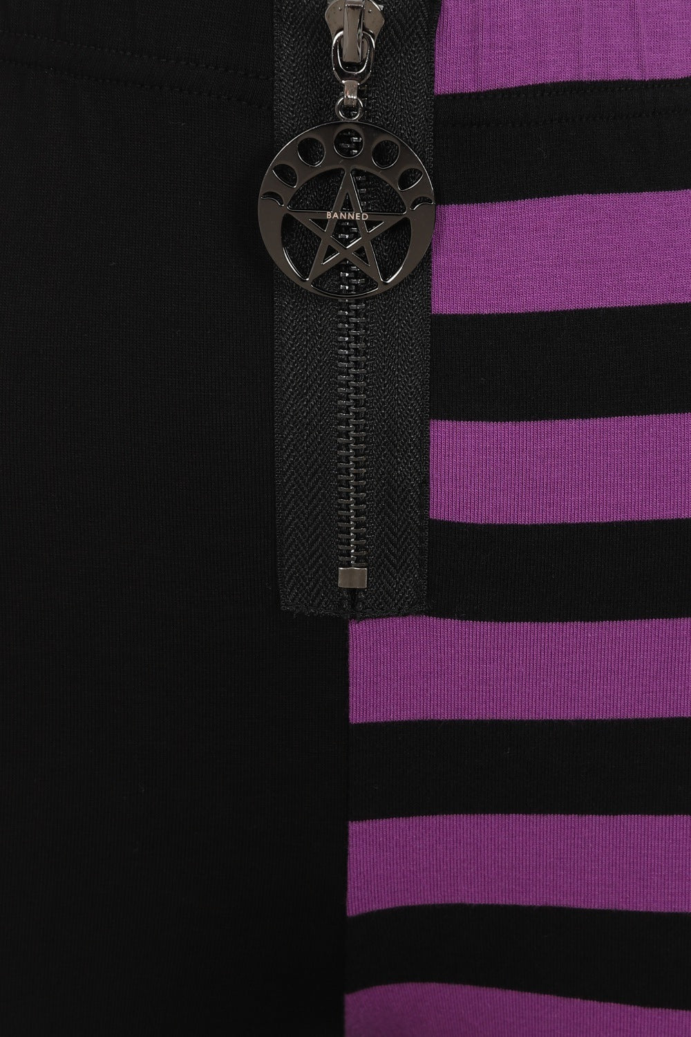 High waisted leggings with one striped purple leg and zip waist and pentagram pendant 
