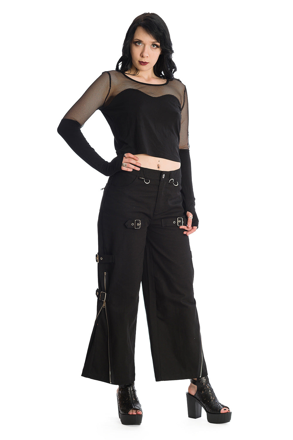 Grunge model wearing mesh long sleeve top with thumb holes in black with oversized black trousers with buckles 