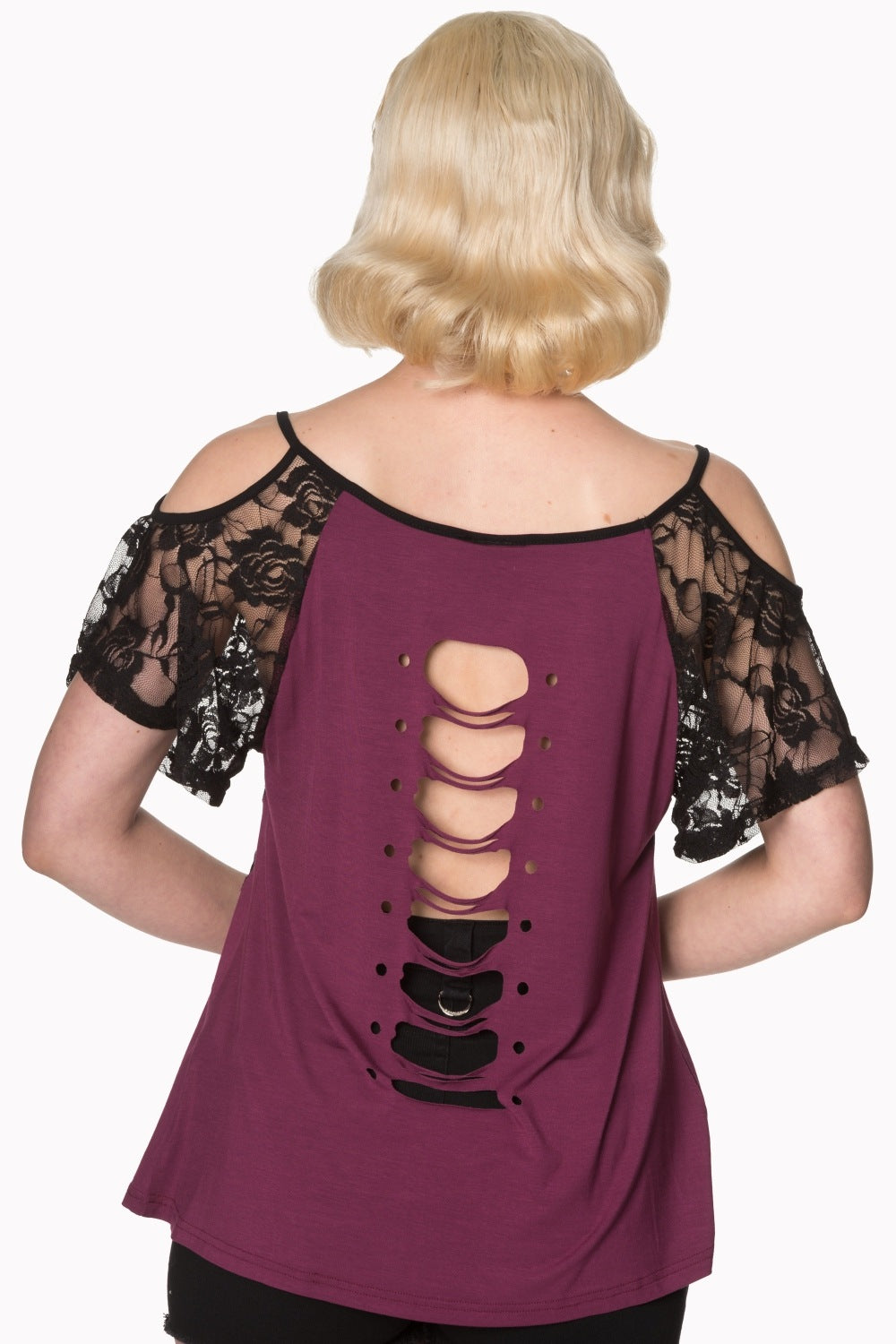 Model wearing lace top with skull detail in purple showing rips on back