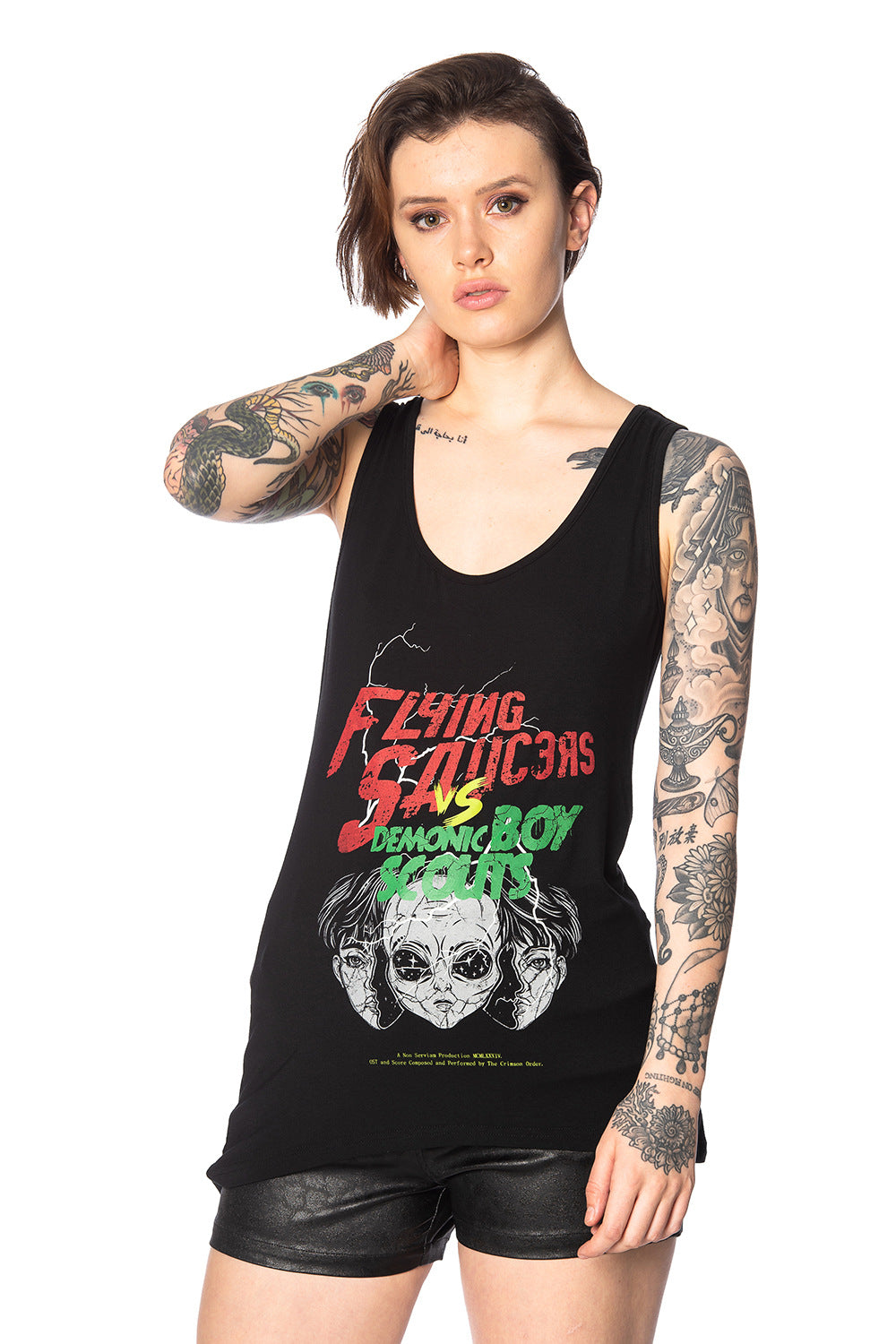 Alternative model with tattoos wears black outfit with movie poster print vest top