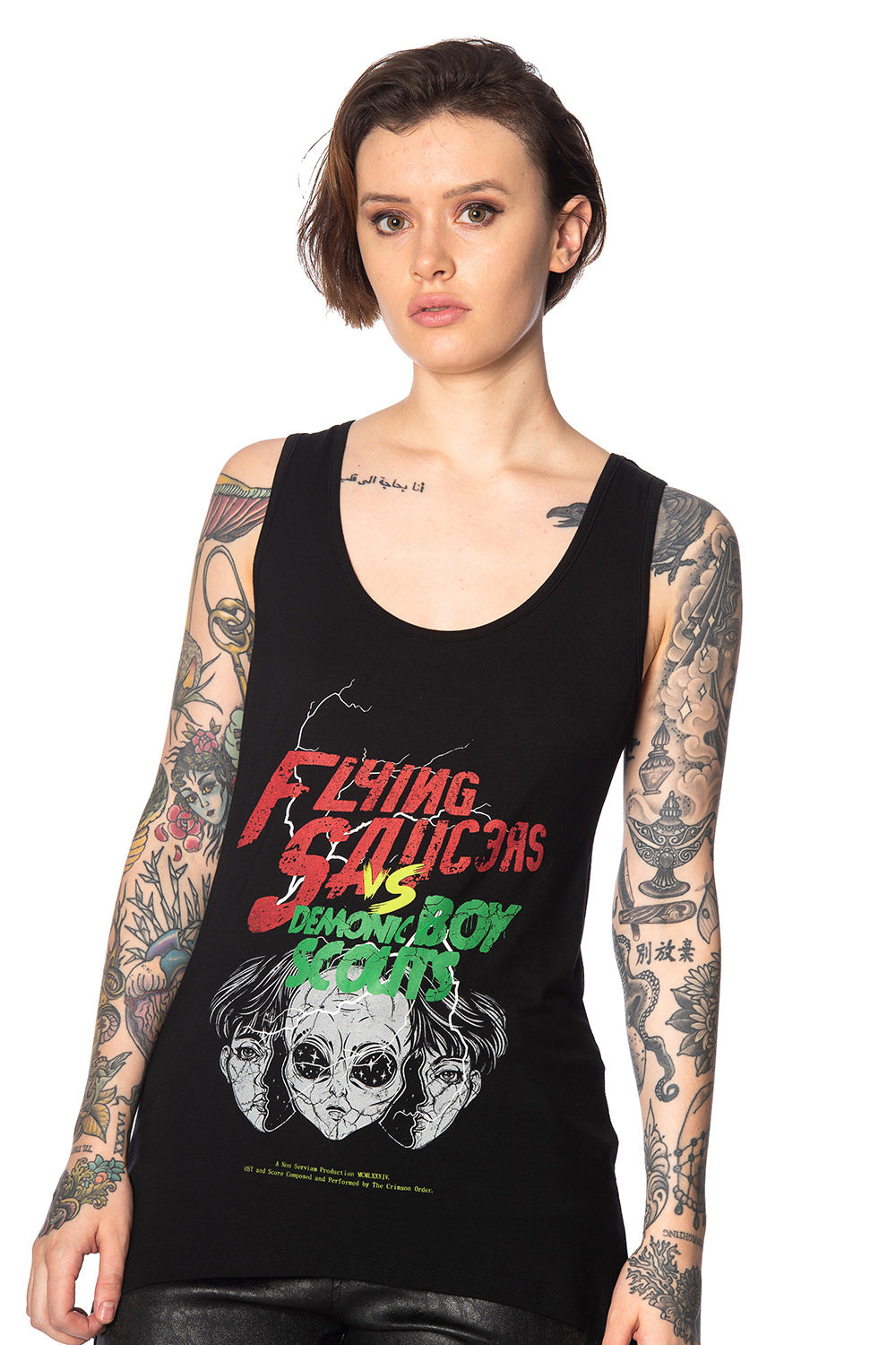 Alternative model with tattoos wears black outfit with movie poster print vest top