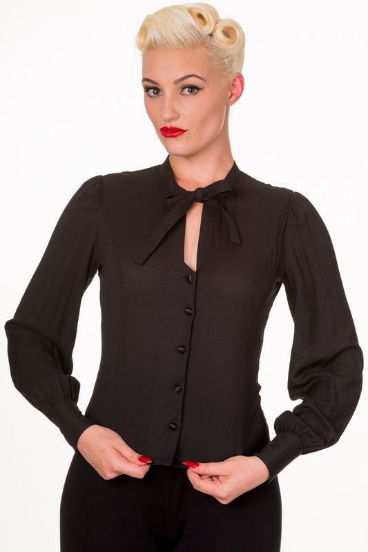 Retro model in black long sleeve shirt with tie up collar