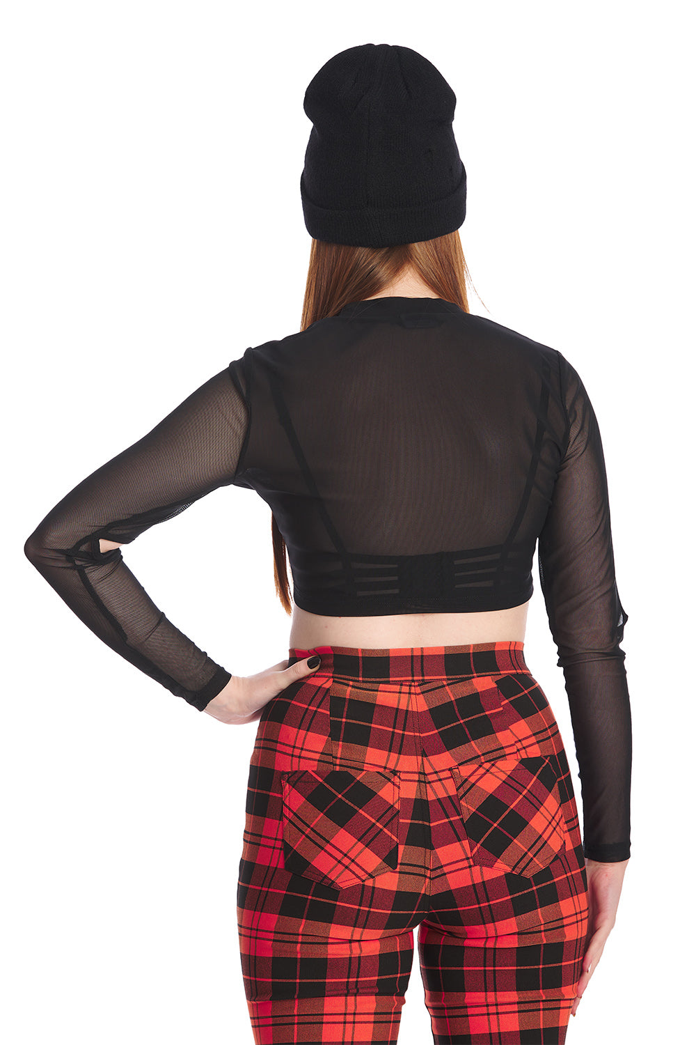 Model wears orange tartan high waisted trousers with a crop mesh top in black and beanie hat
